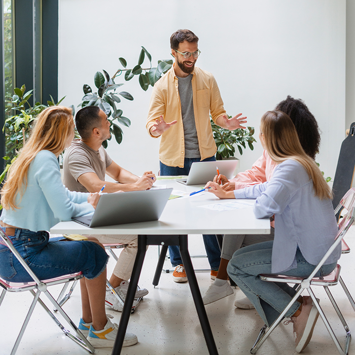 Trainer walking a group of school staff through a new system around a table